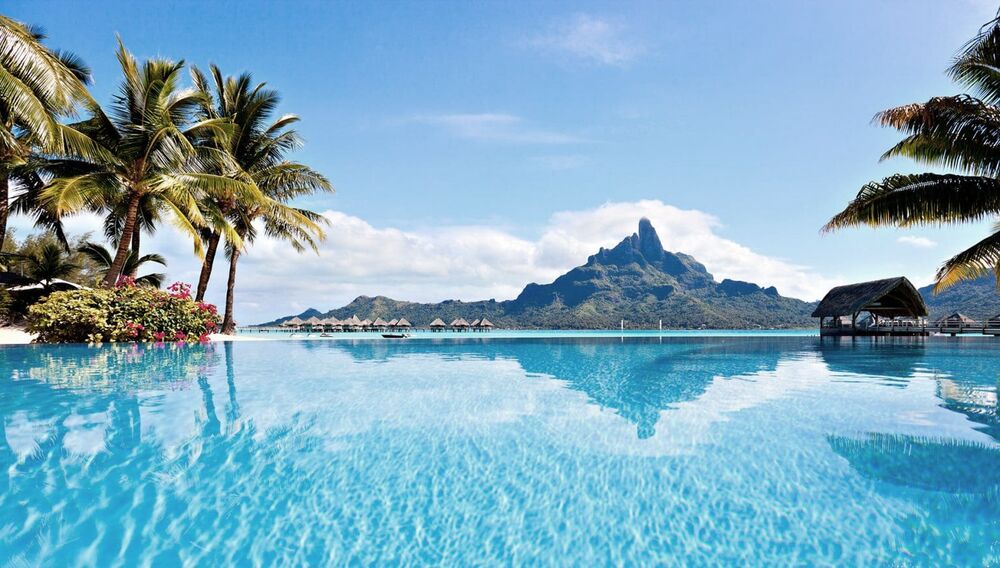 Infinity pool looking across a lagoon to a volcanic peak